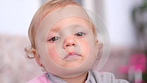 Close up portrait of a cute little girl looking at something on a smartphone.