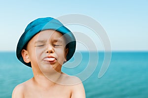 Close-up portrait of a cute, smiling young child at the beach. People, travel, holidays and tourism concept.