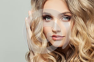 Close up portrait of cute young fashion model woman with long healthy curly hairstyle