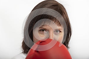 Close up portrait of dark-haired girl in boxing gloves on white background. Women rights event concept