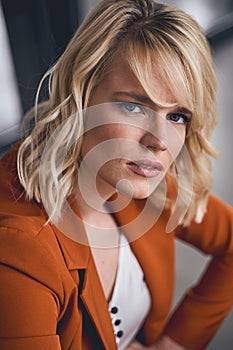 Dispirited stylish blonde Caucasian woman sitting indoors photo