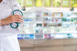 Close-Up Portrait of Doctor Hand is Holding Stethoscope in Front of Drugstore Background, Healthcare and Medicine Concept.