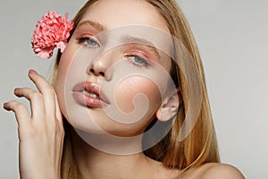 Close up portrait of dreamy blonde girl with trendy makeup touching her face