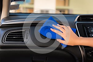 Close-up portrait of a driver woman cleaning her car with microfiber towel