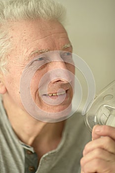 Close-up portrait of an elder man making inhalation