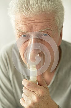 Close-up portrait of an elder man making inhalation