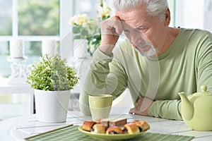 Close up portrait of elderly man drinking cup of coffee