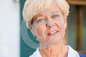 Close-up portrait of an elegant senior woman looking at camera w