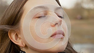 Close up portrait of enjoying woman standing on the wind