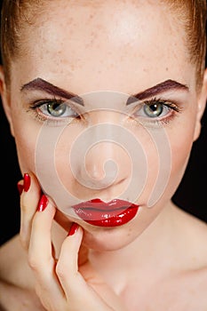 Close-up portrait of european young woman model with glamour make-up and red bright manicure. christmas makeup, bloody red li