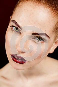 Close-up portrait of european young woman model with glamour make-up and red bright manicure. christmas makeup, bloody red li