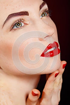 Close-up portrait of european young woman model with glamour make-up and red bright manicure. christmas makeup, bloody red li