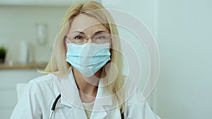 Close up portrait of family medical doctor with glasses is in health clinic. Successful physician in white lab coat and