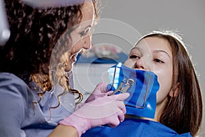 Close-up portrait of a female patient visiting dentist for teeth whitening in clinic