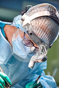 Close up portrait of female surgeon doctor wearing protective mask and hat during the operation. Healthcare, medical