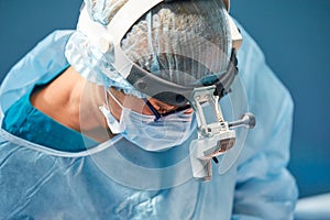 Close up portrait of female surgeon doctor wearing protective mask and hat during the operation. Healthcare, medical