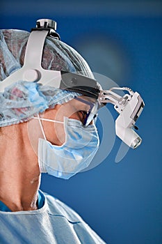 Close up portrait of female surgeon doctor wearing protective mask and hat during the operation. Healthcare, medical