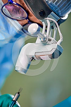 Close up portrait of female surgeon doctor wearing protective mask and hat during the operation. Healthcare, medical