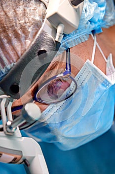 Close up portrait of female surgeon doctor wearing protective mask and hat during the operation. Healthcare, medical