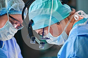 Close up portrait of female surgeon doctor wearing protective mask and hat during the operation. Healthcare, medical