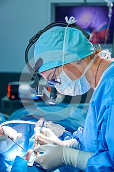 Close up portrait of female surgeon doctor wearing protective mask and hat during the operation. Healthcare, medical