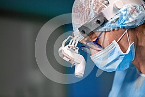 Close up portrait of female surgeon doctor wearing protective mask and hat during the operation. Healthcare, medical