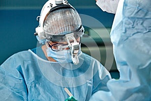 Close up portrait of female surgeon doctor wearing protective mask and hat during the operation. Healthcare, medical