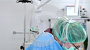 Close-up portrait of female surgeon wearing sterile clothing operating at operating room.