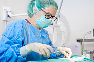 Close-up portrait of female surgeon wearing sterile clothing operating at operating room.