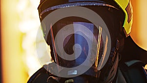 Close up, portrait of firefighter wearing gas mask in front of the burning house