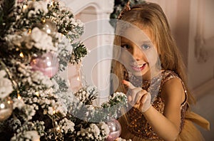 Close up. Portrait of a fun smilling little girl near by Christmas tree. Christmas concept