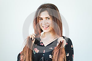 Close up portrait of funny attractive pretty girl with long ginger fair hair standing on white background.