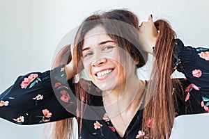 Close up portrait of funny attractive pretty girl with long ginger fair hair standing on white background.