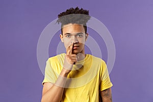 Close-up portrait of funny and unappropriate young hispanic teenage guy picking nose with finger, smiling and looking at