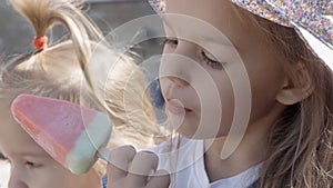 Close up portrait Girl enjoys delicious ice cream cone. Child eating watermelon popsicle. Kids Siblings snack sweets in
