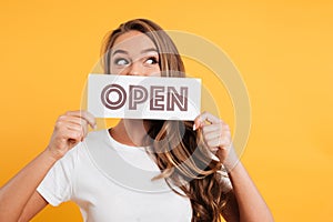 Close up portrait of a girl holding open door sign