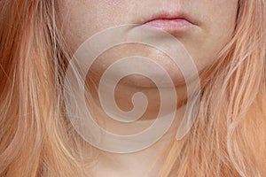 Close-up portrait of a girl with orange hair without makeup and skin retouching.