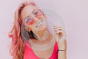 Close-up portrait of glamorous woman with tanned skin posing in sunglasses and black bracelet. Indo