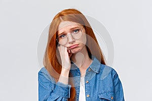 Close-up portrait gloomy unhappy redhead sad girl in glasses, teenager having bad day at college, leaning on hand