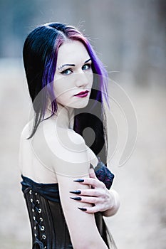 Close-up portrait of the gothic woman in the dark forest