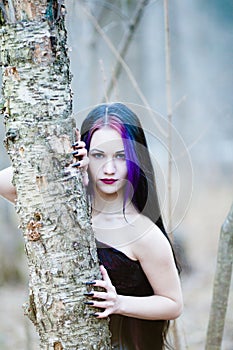 Close-up portrait of the gothic woman in the dark forest