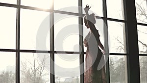 Close-up portrait of a graceful ballet dancer. silhouette of young ballerina on window background. slow motion