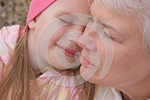 Close up portrait of grandmother and granddaughter . Having good times with grandparent outdoors