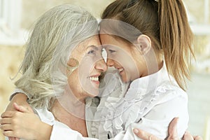 Close up portrait of grandmother with her cute granddaughter smiling