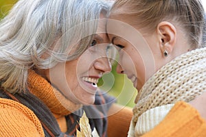Close up portrait of granny and granddaughter posing outdoors