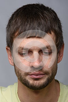 Close-up portrait of a grieved downcast European-looking man who puffed out his cheeks