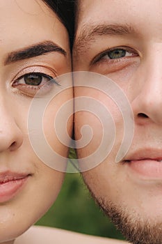 Close up portrait of groom and bride in park. Face to face, hulf face