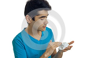 Close-up portrait of a guy in a t-shirt which seriously impair shaving foam on hand photo