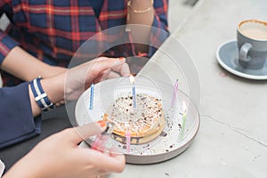 Close up portrait of hand light up candle in pancake to preparing surprise birthday party