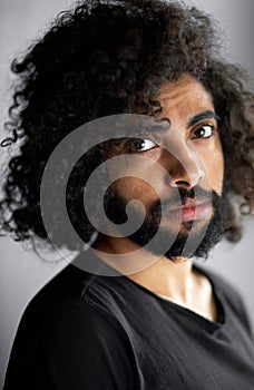 Close-up portrait of handsome calm arab man in black shirt posing in studio